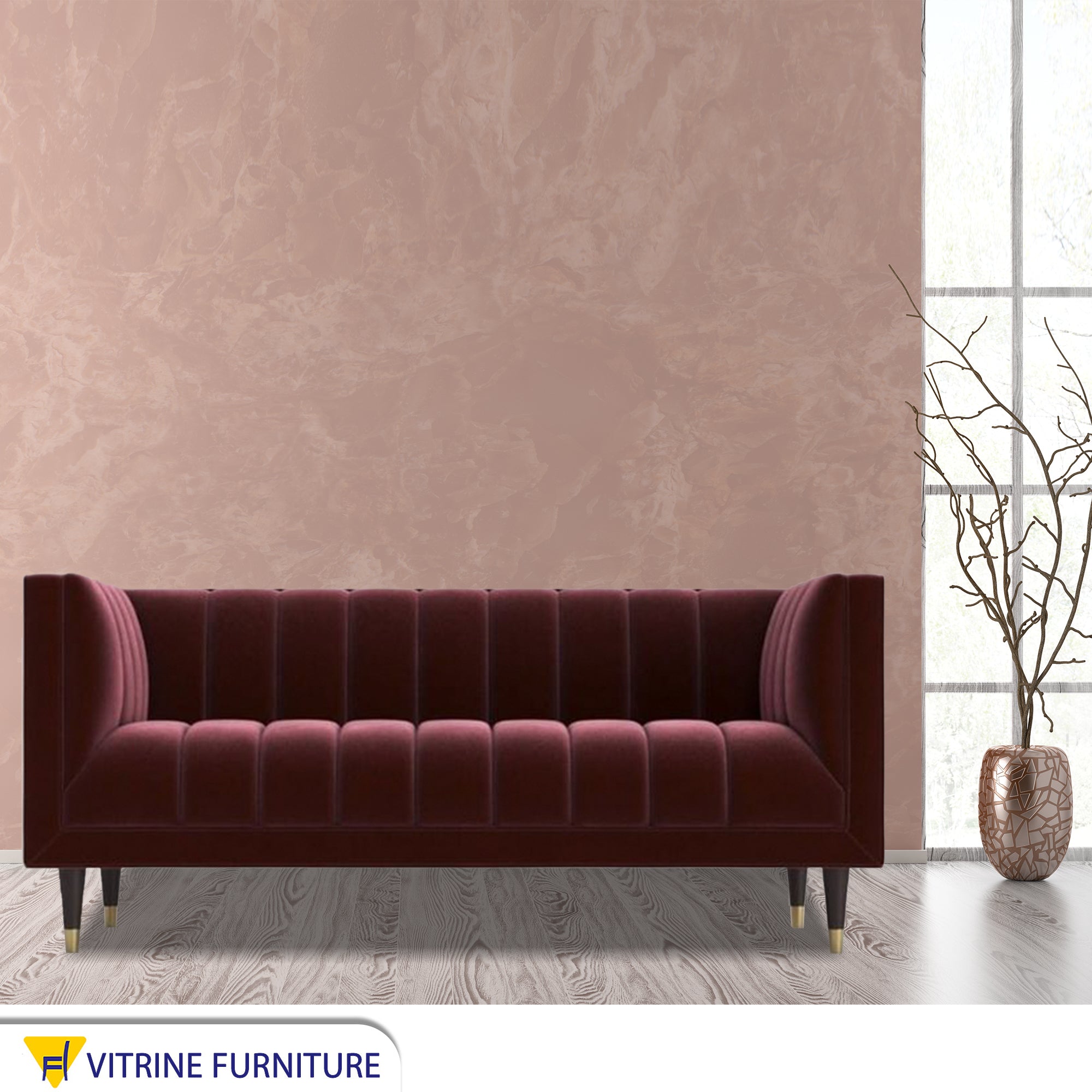 A sofa in a burgundy color with recessed lines on the back and the base