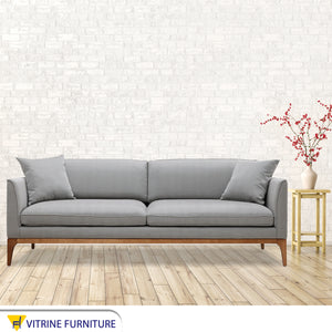 Gray sofa with high wooden legs