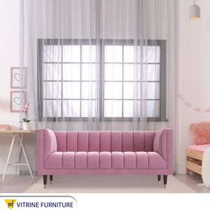 Rose color sofa with recessed lines on the back and base