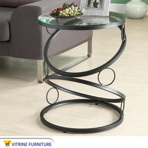 A circular table in black with a unique design