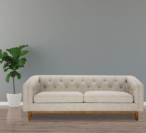 A beige sofa with capotonite grains, with armrests and backrest