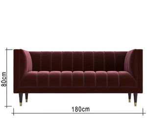 A sofa in a burgundy color with recessed lines on the back and the base