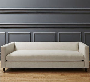 Off white sofa with attached back and armrests