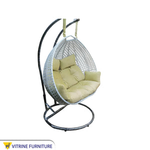 White and yellow swing chair for two people