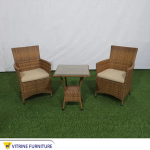 An outdoor set of 2 brown chairs and a table