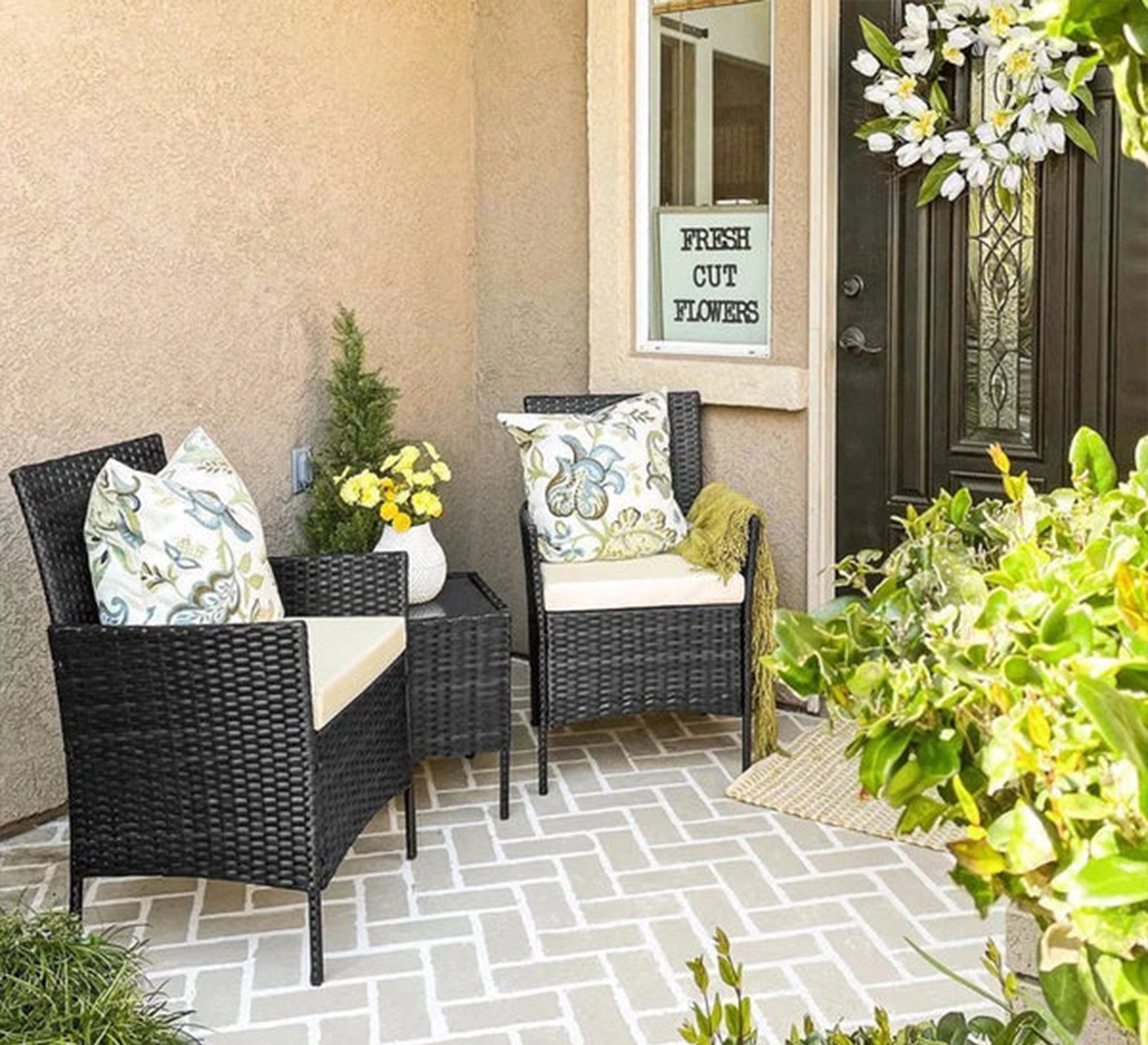 An outdoor set of 2 black chairs and a table