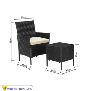 An outdoor set of 2 black chairs and a table