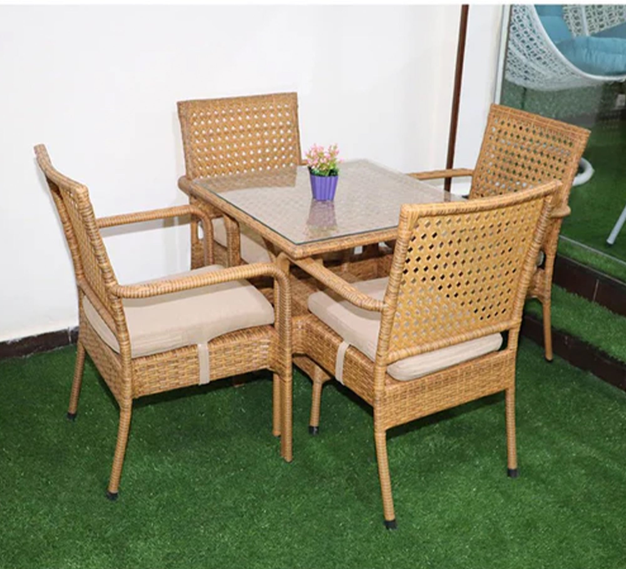 An outdoor set of 4 beige chairs and a table