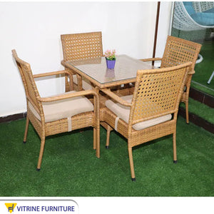 An outdoor set of 4 beige chairs and a table