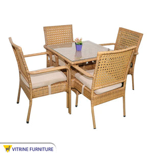 An outdoor set of 4 beige chairs and a table