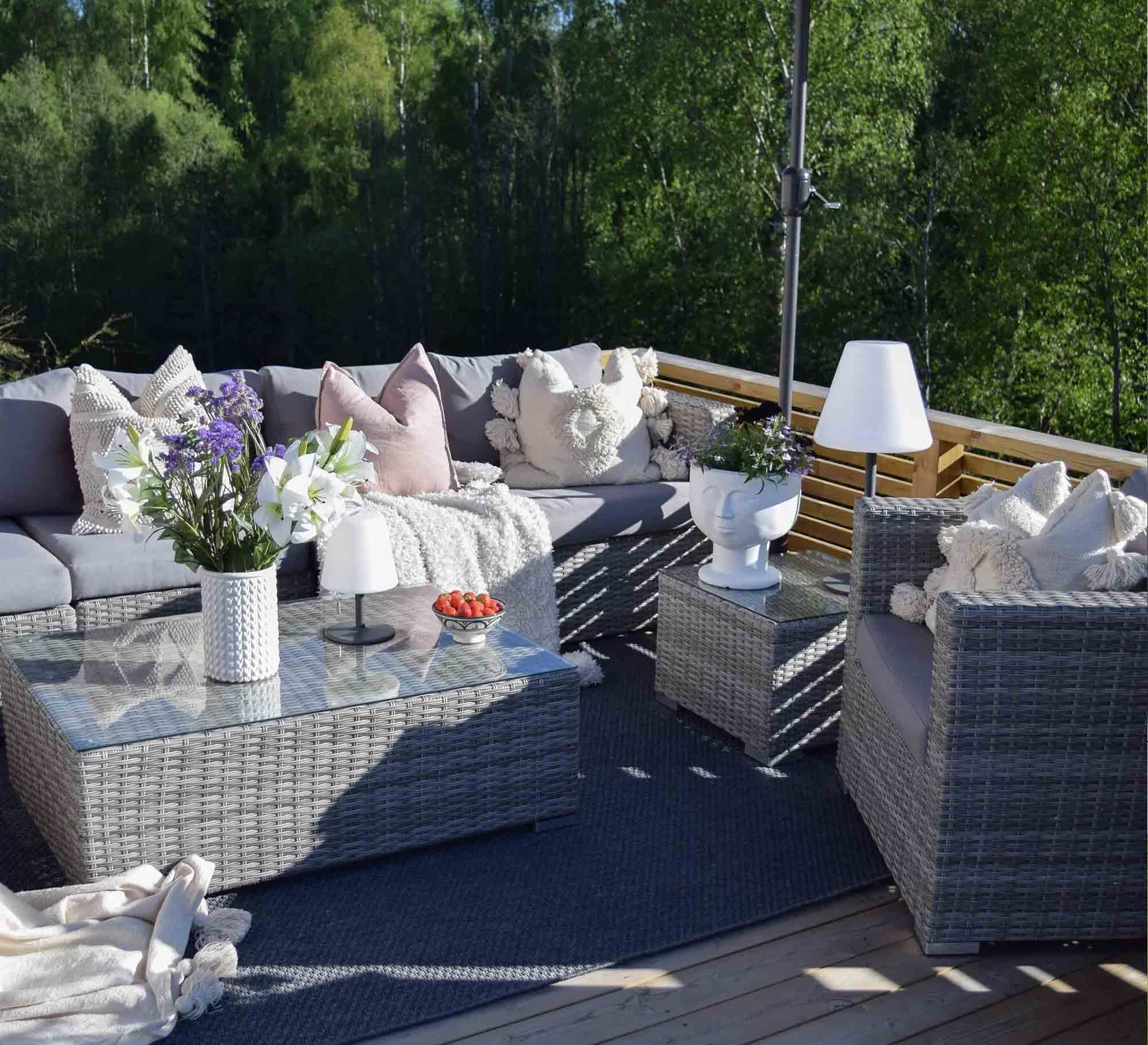 An outdoor set with a corner, a chair and two tables