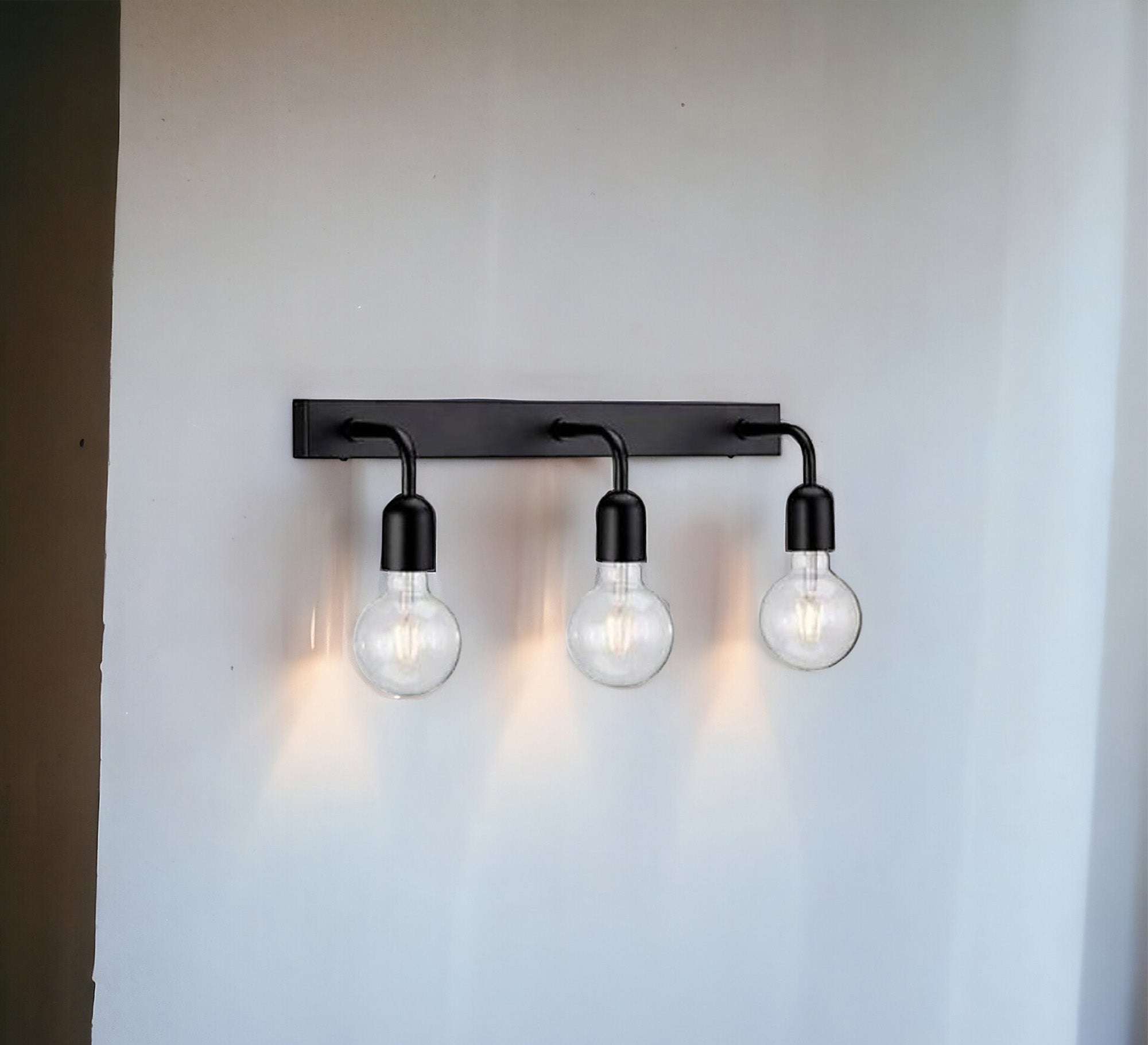 A Wall Sconce with three lamps with a metal base