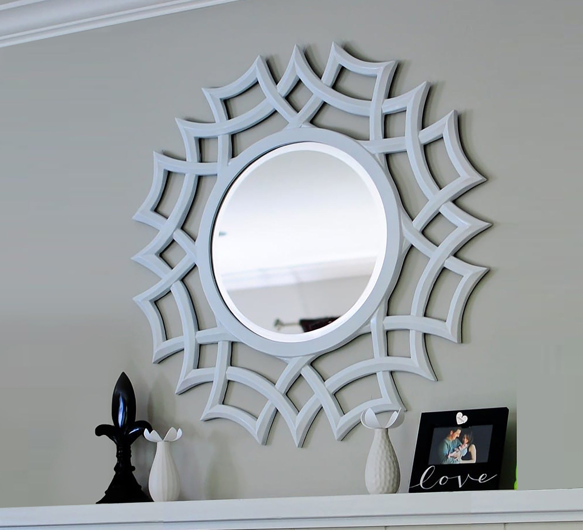 A circular mirror with a frame of hollow overlapping circles