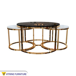 Three golden tables with black and white marble