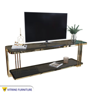 A rectangular gold TV table with two shelves