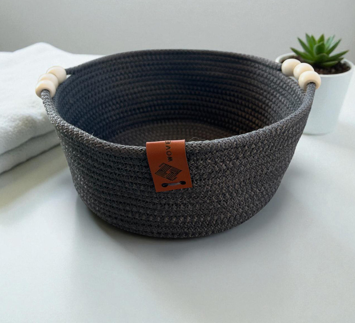 Low round basket with leather handles and cheerful colors